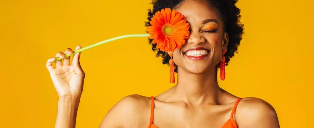 women smiling holding flower