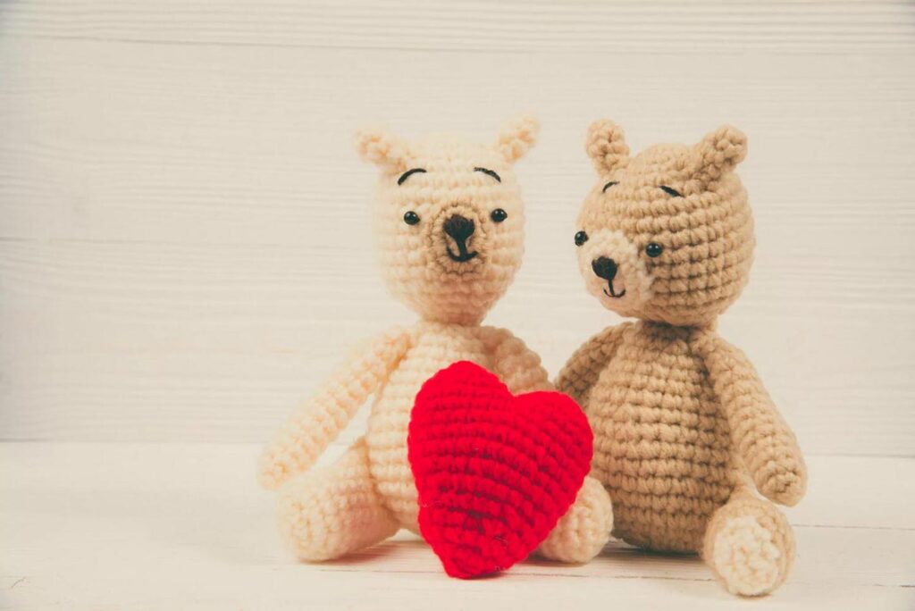 two teddies holding heart