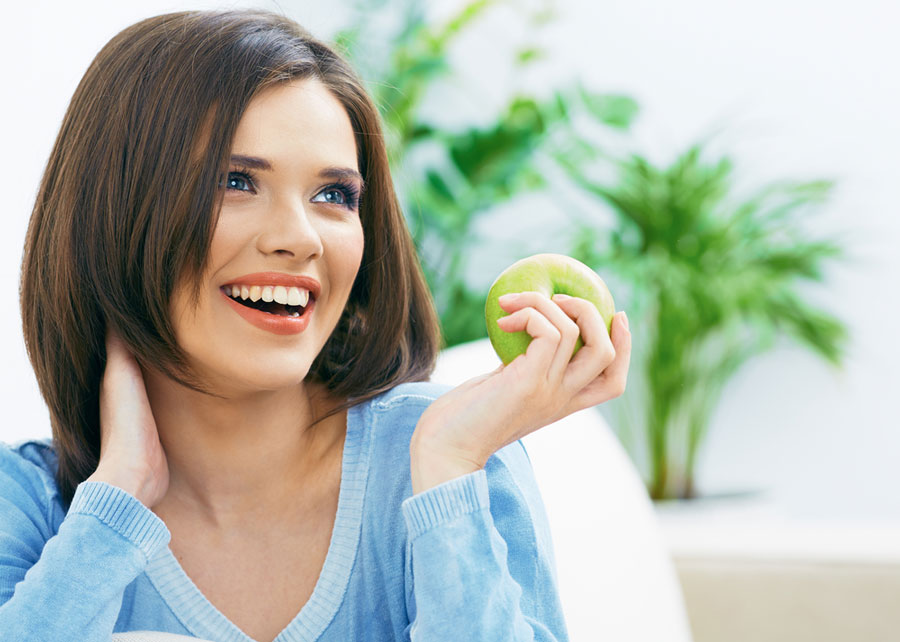 a woman eating an apple and smiling